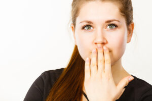 A woman covering her mouth.